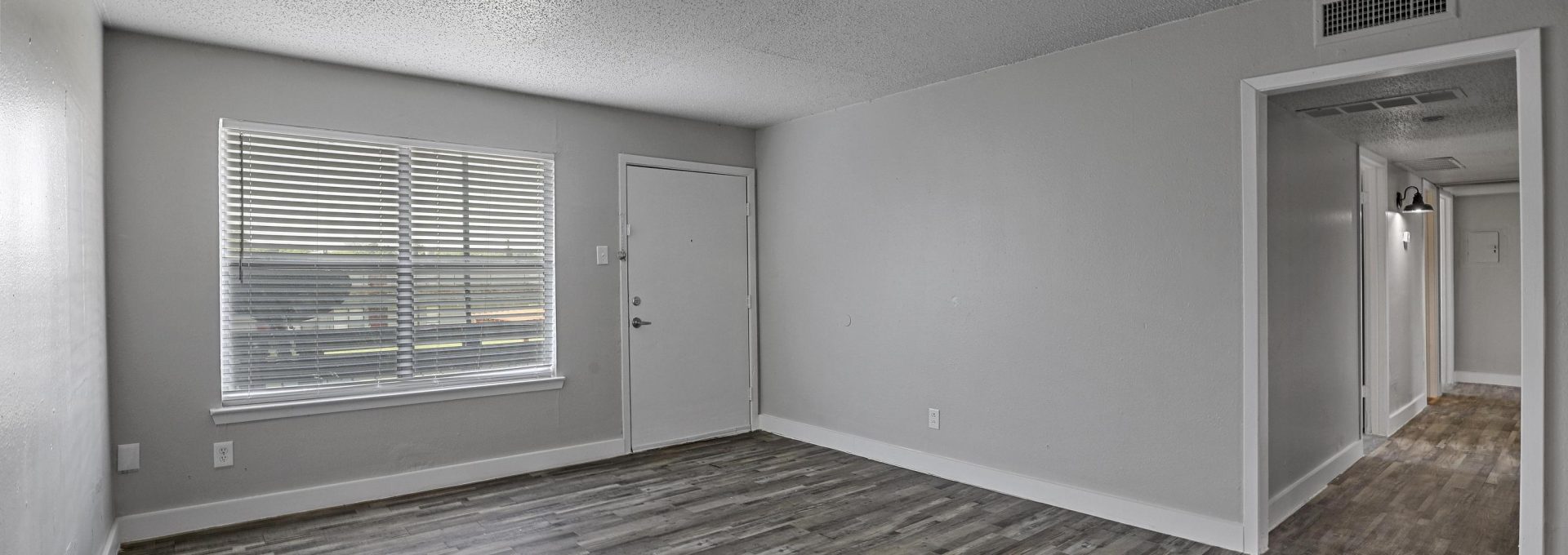 empty room with hardwood floors and gray walls at The Flats on Handley