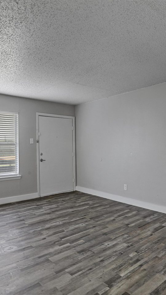 empty room with hardwood floors and gray walls at The Flats on Handley