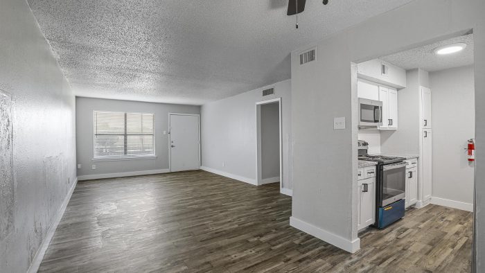 an empty room with hardwood floors and a ceiling fan at The Flats on Handley