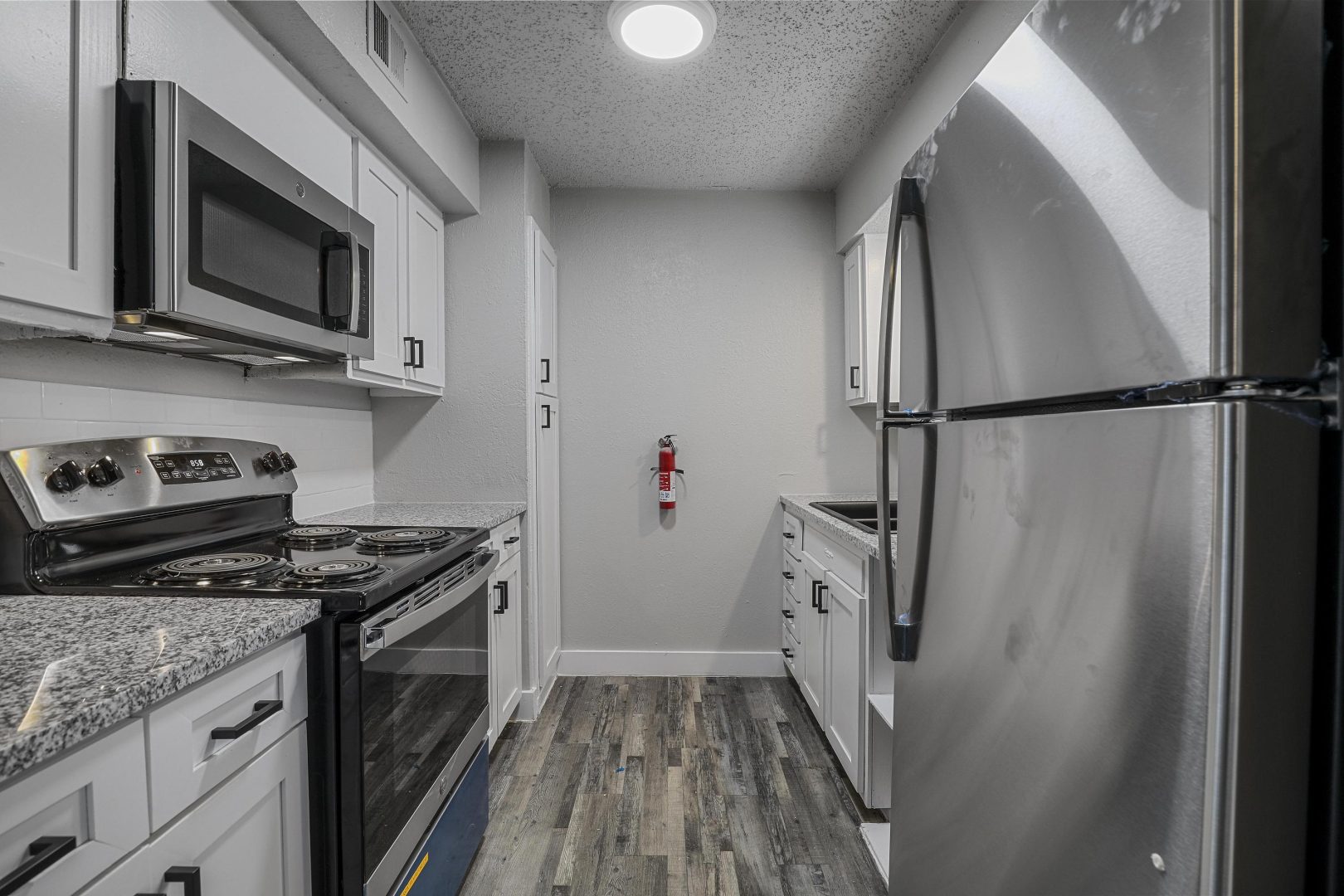 kitchen with stainless steel appliances and white cabinets at The Flats on Handley