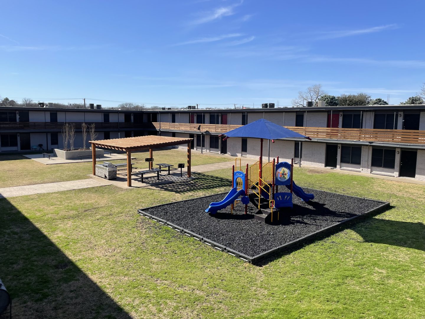 a playground area with a slide and swings at The Flats on Handley