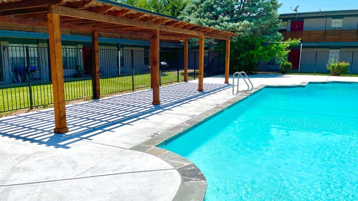 a pool with a gazebo and patio furniture at The Flats on Handley