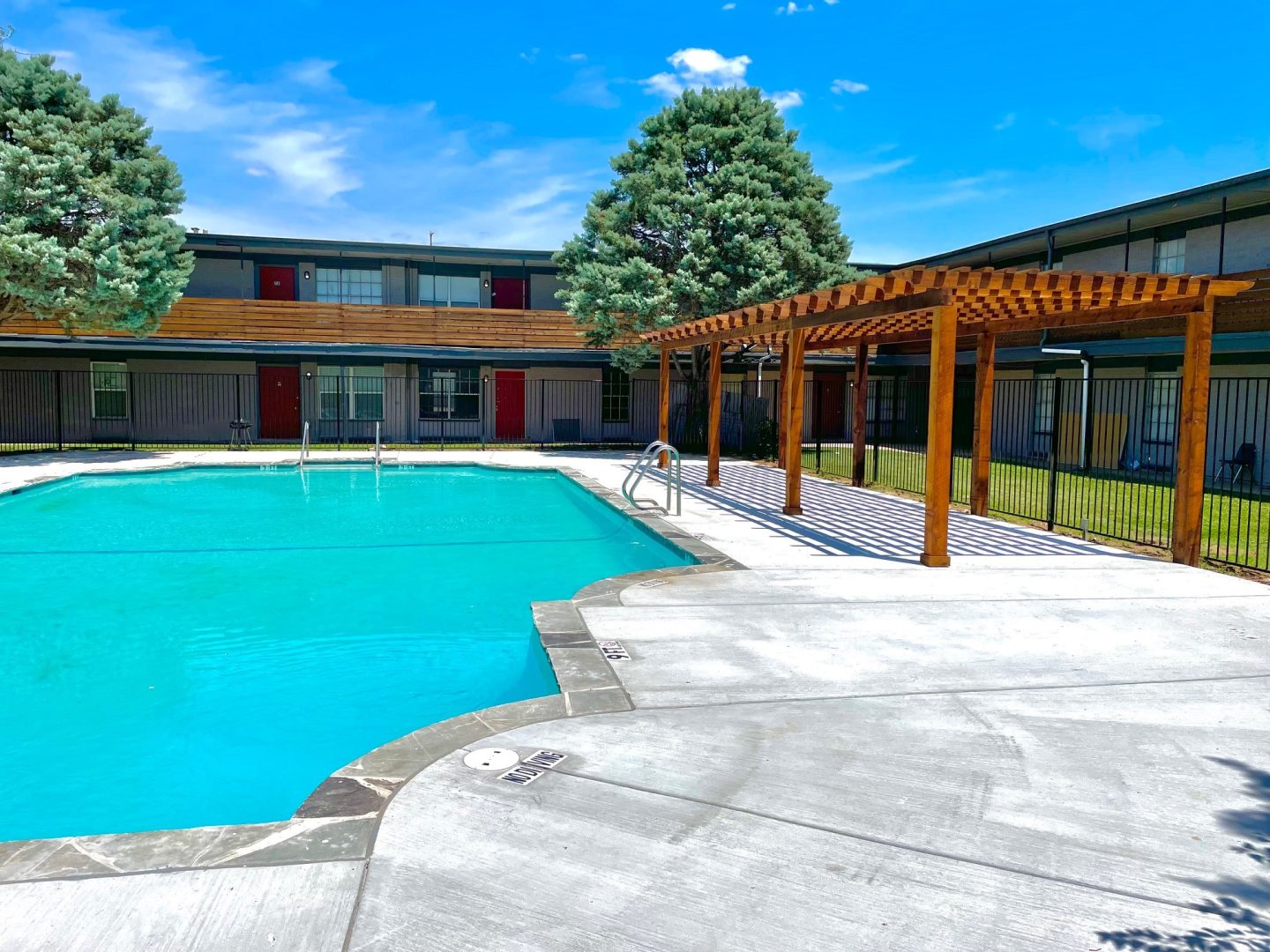 a pool with a gazebo and patio furniture at The Flats on Handley