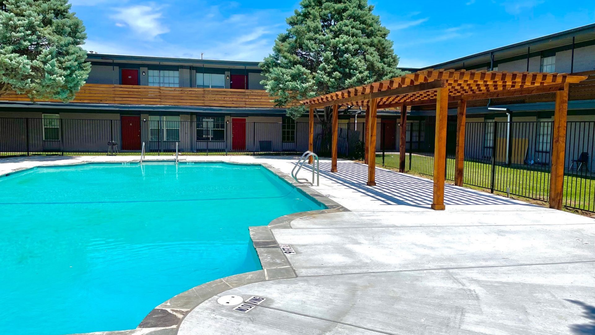 a pool with a gazebo and patio furniture at The Flats on Handley